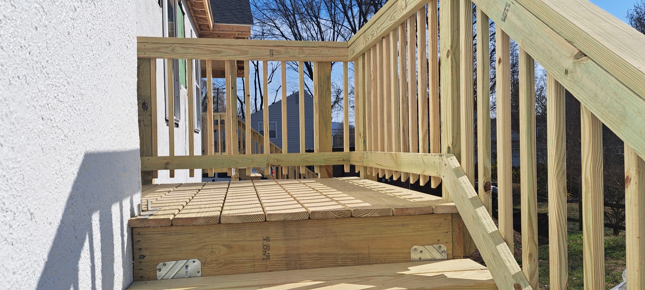 New wood deck landing with stair railings and balusters